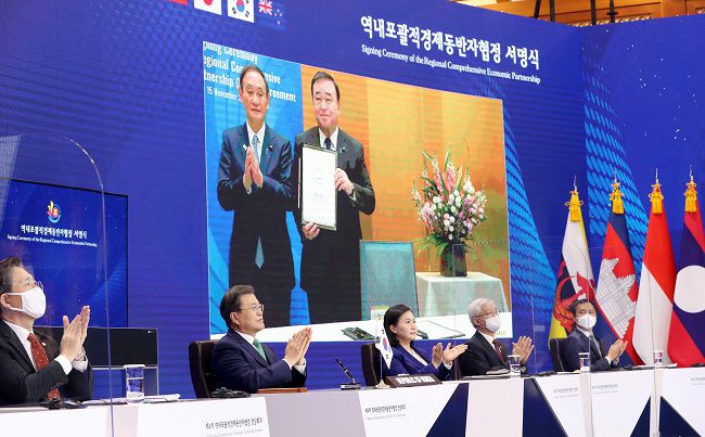 문재인 대통령과 유명희 장관이 청와대에서 화상회의로 열린 RCEP 정상회의 및 협정 서명식에서 일본의 서명식을 보며 박수치고 있다/사진=매경DB