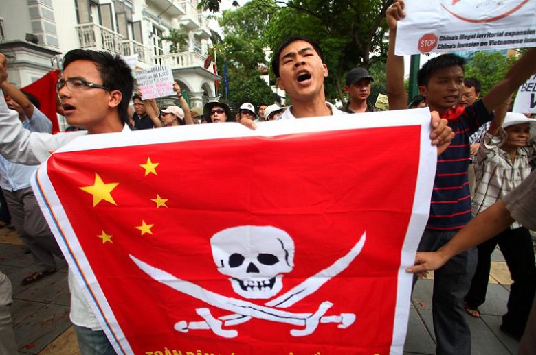 지난 2011년 베트남인들이 중국 국기에 해적기를 합성한 깃발을 들고 남중국해 관련 중국을 규탄하는 모습.[사진=연합뉴스]