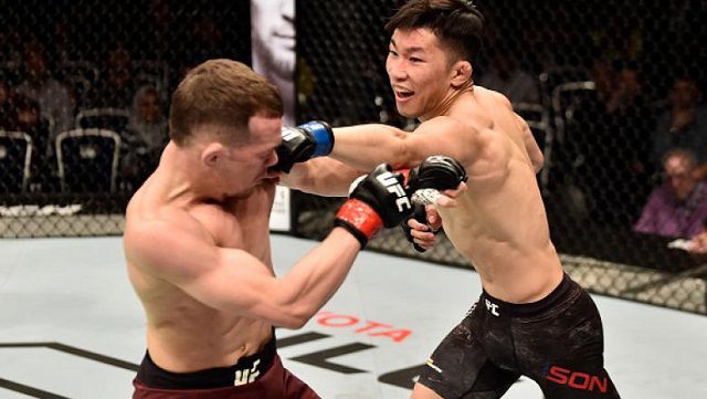 손진수(오른쪽)가 2018년 모스크바에서 치른 UFC 데뷔전에서 훗날 밴텀급 챔피언이 되는 페트르 얀(왼쪽)을 공격하고 있다. © Ultimate Fighting Championship