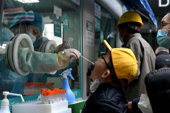 중국이 신종 코로나바이러스 감염증(코로나19) 확산으로 비상인 가운데 14일 수도 베이징에서 의료진이 코로나19 검사를 위해 한 소년의 검체를 채취하고 있다. [사진 출처 = 연합뉴스]
