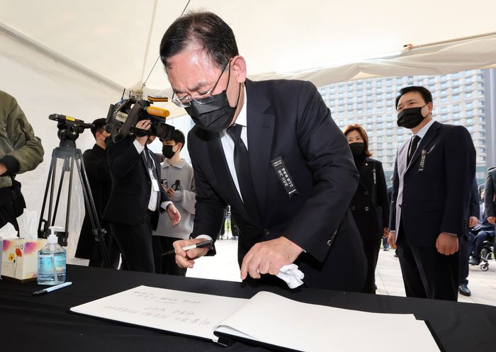 주호영 국민의힘 원내대표가 1일 오전 서울광장에 마련된 이태원 사고 사망자 합동분향소를 찾아 헌화를 마친 뒤 조문록을 작성하고 있다.  <연합뉴스>