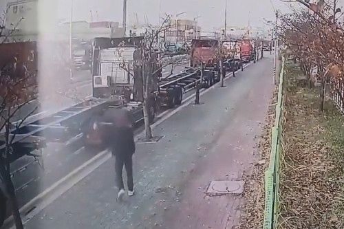 지난달 26일 부산항 신항 인근 도로에서 화물연대 조합원이 새총으로 비조합원이 운행하는 트레일러 차량에 쇠구슬을 쏘는 모습. [자료=부산경찰청]