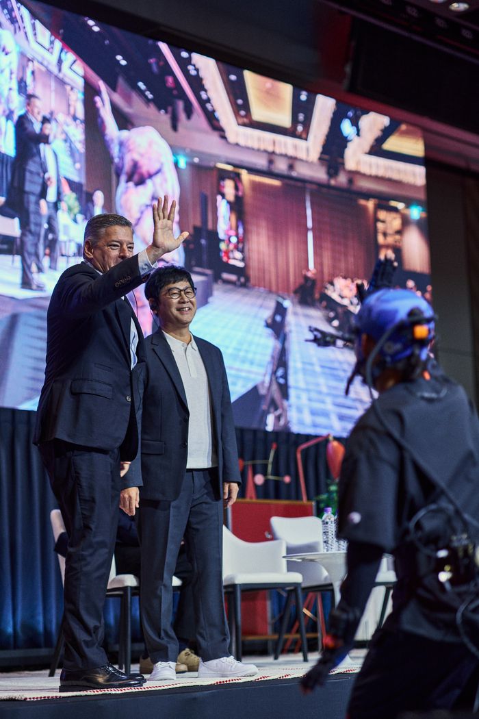 22일 기자간담회에서 테드 서랜도스 넷플릭스 CEO(왼쪽)가 실시간으로 화면에 괴물 크리쳐로 구현된 모션 연기자와 하이파이브를 하고 있다. 시리즈 ‘스위트홈’ 등에 참여한 국내 VFX 제작사 웨스트월드의 기술력으로 이날 현장에서 시연됐다. 사진제공=넷플릭스