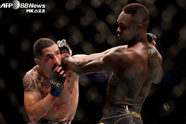이스라엘 아데산야(오른쪽)가 로버트 휘터커와 UFC 미들급 타이틀 4차 방어전에서 공격을 주고받고 있다. 사진=AFPBBNews=News1