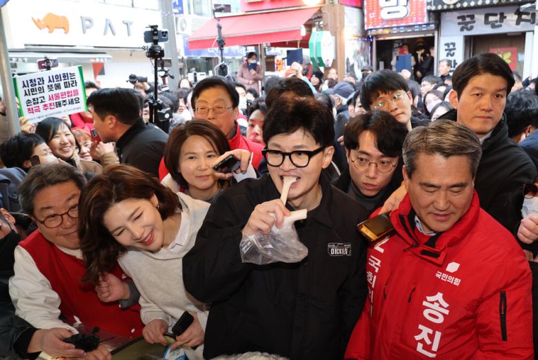한동훈 국민의힘 비상대책위원장이 설 명절을 앞둔 2일 경기도 구리시 구리전통시장의 한 떡집을 방문해 가래떡을 먹고 있다.  김호영 기자