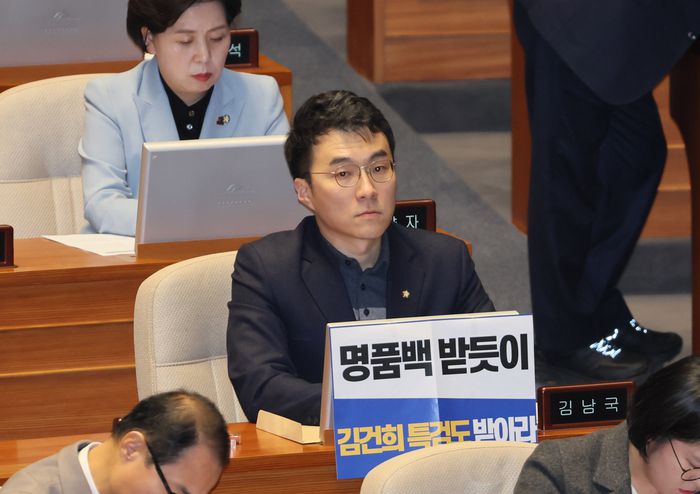 김남국 의원이 지난해 12월 28일 국회 본회의에서 김건희 여사 특검법 수용을 촉구하는 손팻말을 붙이고 있다. [출처 : 연합뉴스]