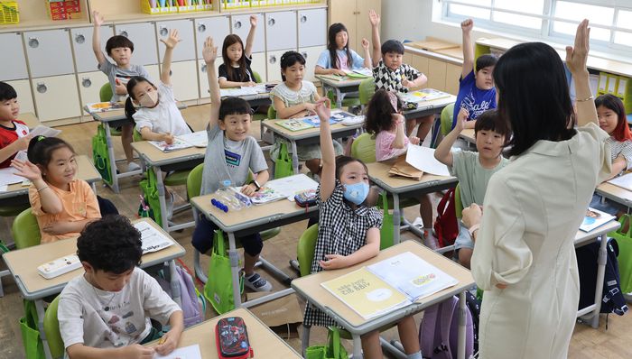 지난달 29일 오전 부산 북구의 한 초등학교 교실에서 여름방학을 마치고 등교한 학생들이 선생님에게 방학 이야기를 발표하고자 손을 들고 있다. 사진은 기사 내용과 직접적인 관련 없음. [사진 출처 = 연합뉴스]