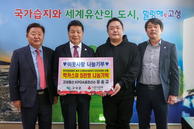 유송규(왼쪽 세번째)가 지난 22일 고성군청을 찾아 홀인원 경품으로 받은 박카스 5000병을 기탁한 뒤 기념촬영을 하고 있다.