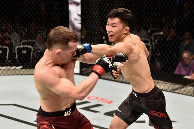 손진수(오른쪽)가 훗날 제8대 UFC 밴텀급 챔피언이 되는 중국계 파이터 표트르 양을 2018년 9월 러시아 모스크바 원정경기로 상대하며 특유의 웃음을 짓고 있다. 사진=TKO