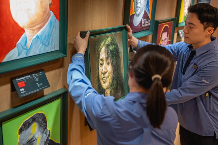 전시 공간에 한강 초상화를 거는 교보문고 직원들.  <교보문고>