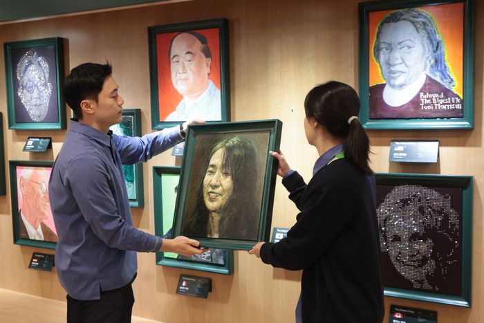 10일 서울 교보문고 광화문점 노벨상 수상자 전시 공간에 직원들이 한강 작가의 초상을 걸고 있다. 이 공간은 과거 각 부문 수상자의 초상화와 미래 노벨상 수상자를 위한 빈 공간을 함께 전시하며 ‘당신이 이 자리의 주인공입니다’라는 메시지를 전해왔다. <연합뉴스>