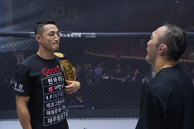양지용(왼쪽)이 제2회 로드FC 글로벌 토너먼트 우승을 자신하며 챔피언 벨트를 어깨에 두른 채 김수철과 마주 보고 있다. 사진=세계격투스포츠협회