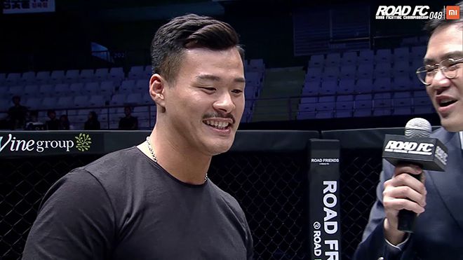 황인수(왼쪽)가 라인재 로드FC 타이틀매치 승리를 현장에서 지켜본 후 케이지 안으로 들어와 “Young Guns(언더카드) 경기인 줄 알았다”면서 수준을 깎아내리며 챔피언을 도발하고 있다. 오른쪽은 KMMA 정용준 대표. 사진=세계격투스포츠협회