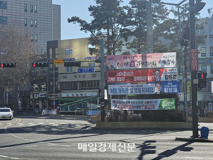 옥외광고물법 시행령에 따르면 가로등, 전봇대 등에 현수막을 많이 설치할 경우 전도위험이 있어 정당 현수막을 2개 초과해 설치할 수 없고, 횡단보도 인근 10m내에는 2.5m 미만 높이의 정당 현수막을 설치할 수 없다. 지난 23일 합정역교차로에 설치된 정당 현수막이 해당 규정들을 위반한 모습. [지혜진 기자]