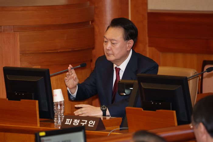 윤석열 대통령이 지난달 23일 서울 종로구 헌법재판소에서 열린 탄핵심판 4차 변론에 출석해 마이크를 조작하는 모습. [사진 출처 = 공동취재단, 연합뉴스]