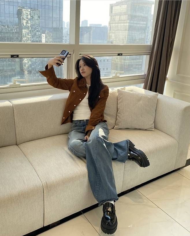 안유진은 브라운 스웨이드 재킷에 크롭 화이트 티셔츠를 매치해 빈티지하면서도 세련된 무드를 연출했다.사진=안유진 SNS