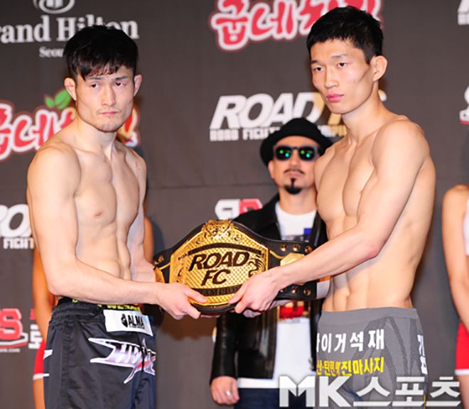 가스가이 다케시(왼쪽)가 2015년 2월 계체 통과 후 로드FC 플라이급 잠정 챔피언 결정전 성사 기념 촬영을 하고 있다. 오른쪽은 제2대 로드FC 플라이급 챔피언이 되는 송민종. 사진=김재현 기자