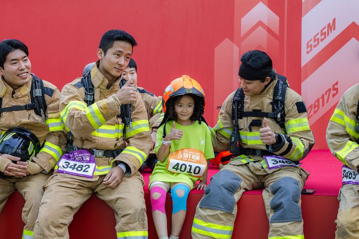롯데월드타워 ‘스카이런’에 참가한 소방관들이 어린이와 함께 사진을 찍고 있다. <사진=롯데물산>