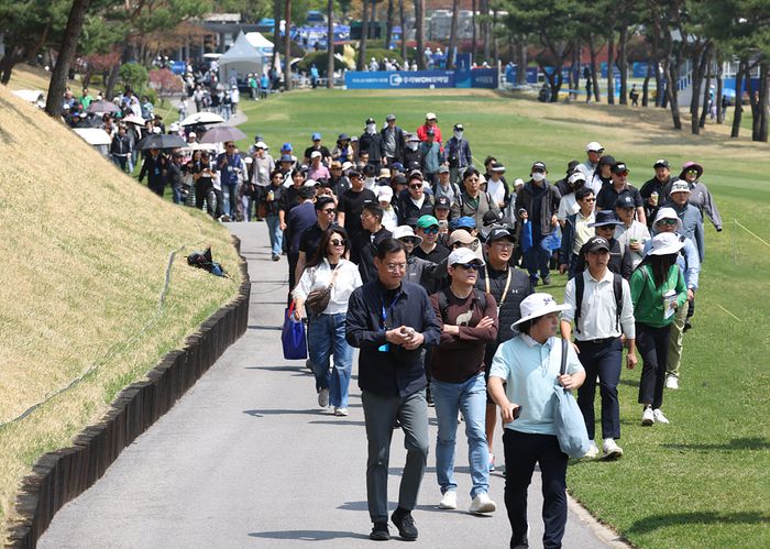 KPGA 투어 우리금융 챔피언십에서 선수들의 경기를 보기 위해 서원밸리 컨트리클럽 1번홀을 걷고 있는 관중들. KPGA