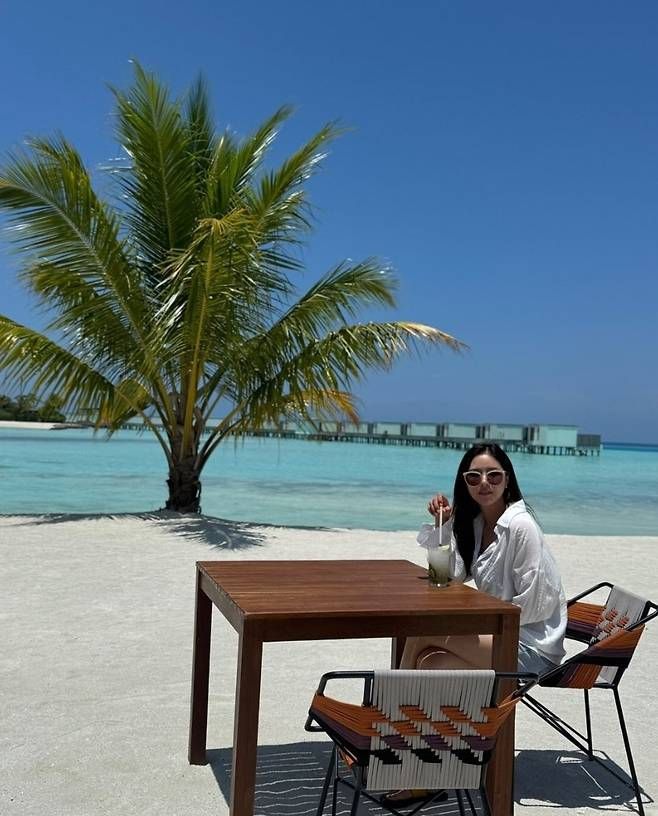 화이트 셔츠에 핑크 톤 선글라스를 매치해 세련되고 감각적인 해변룩을 선보였다.사진=박하나 SNS