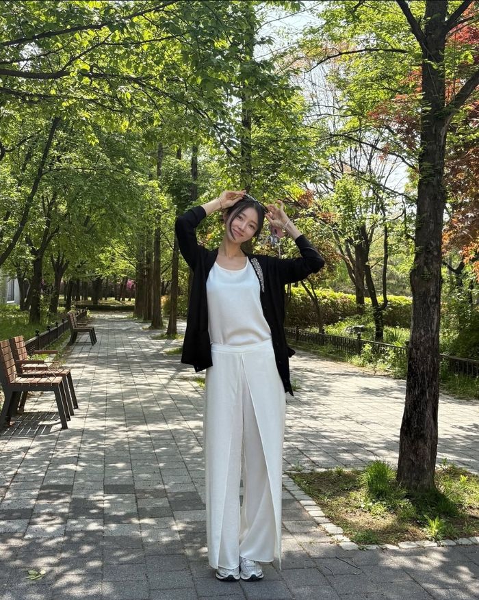 초록이 가득한 산책길 위, 흰 팬츠와 블랙 가디건을 입은 서하얀이 귀엽게 포즈를 취하고 있다. 사진=서하얀 sns