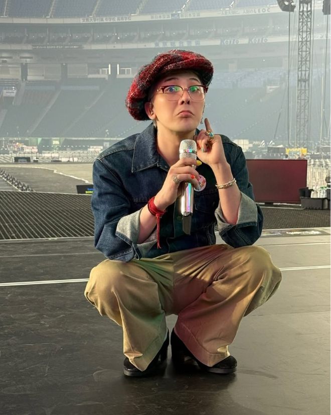 동그랗게 웅크린 채 마이크를 든 지드래곤이 장난기 가득한 표정을 짓고 있다.사진=지드래곤 SNS