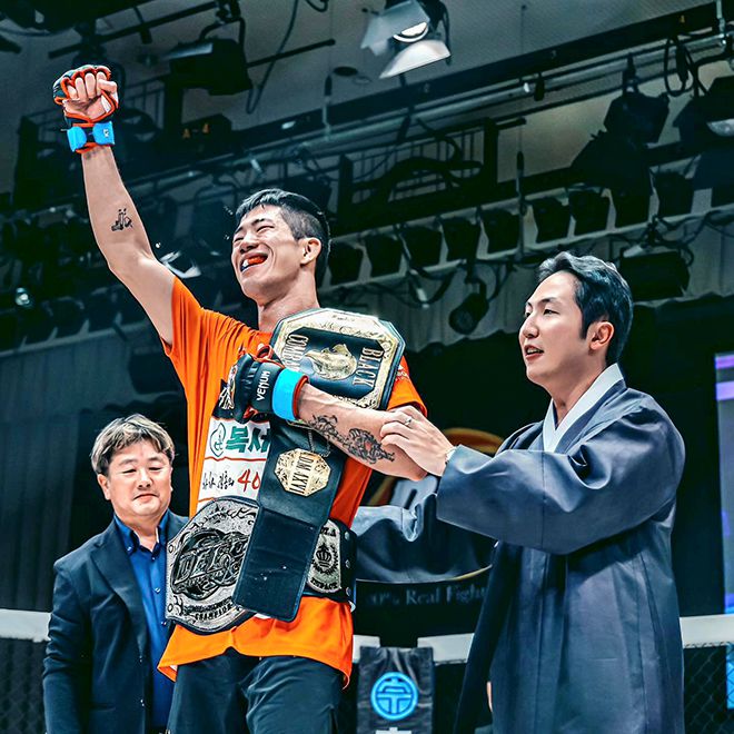 이송하가 2023년 9월 일본 도쿄 고라쿠엔홀에서 제2대 블랙컴뱃 라이트급 챔피언 타이틀 2차 방어 성공 및 제11대 DEEP 라이트급 챔피언 등극 후 기뻐하고 있다. 왼쪽은 사에키 시게루 DEEP 대표, 오른쪽은 박평화 블랙컴뱃 대표. 사진=이데아 파라곤
