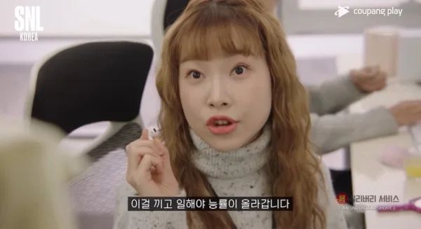 ‘맑은 눈의 광인’으로 SNL에서 한 때 ‘오피스빌런’ 역할을 하던 김아영 배우. 에어팟을 끼고 일해야 능률이 올라간다는 장면. 사진과 기사는 관련 없음. [사진 = 쿠팡플레이]