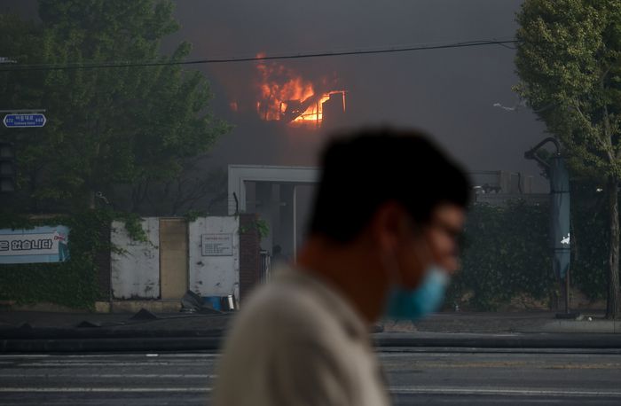 17일 오후 광주 광산구 송정동 금호타이어 광주공장에서 화재로 연기가 나오는 가운데 한 시민이 마스크를 끼고 이동하고 있다. 연합뉴스