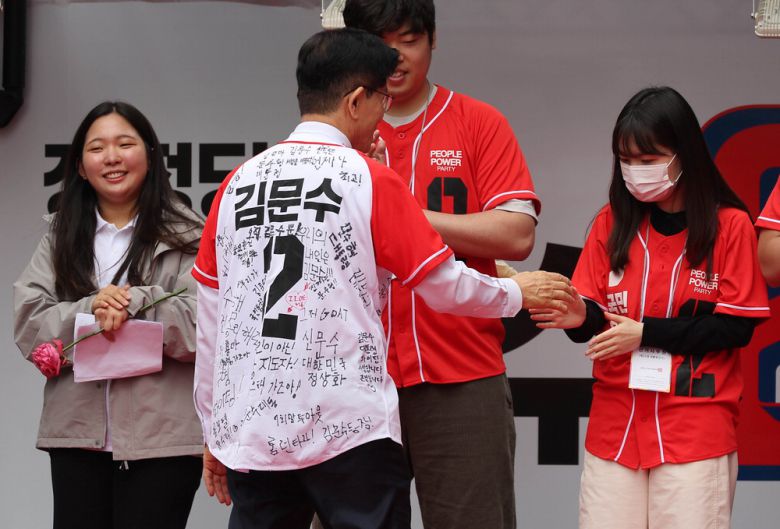 청년들의 응원 메시지가 적힌 옷을 입은 김문수 국민의힘 후보가 19일 청계광장에서 청년들을 만나고 있다. 이충우 기자