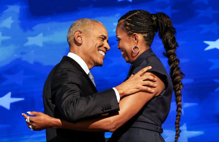 버락 오바마 전 미국 대통령(왼쪽)과 미셸 오바마 여사가 민주당 전당대회 무대에서 포옹하고 있다. 오바마 부부는 나란히 연사로 등장해 해리스 민주당 대통령 후보에게 힘을 실어줬다. <로이터연합>