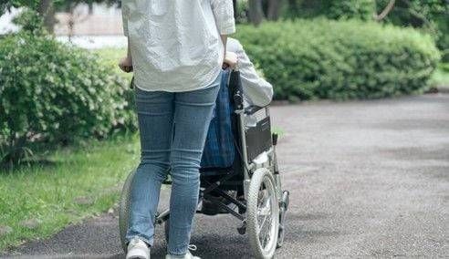 간병인이 휠체어에 앉은 환자를 돌보고 있다. 본 기사와 관련 없음 [사진 = 연합뉴스]