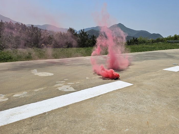 < 연막탄이 붉은색 연기를 뿜어내며 활발히 연소되고 있는 모습 / 태경전자 제공 >