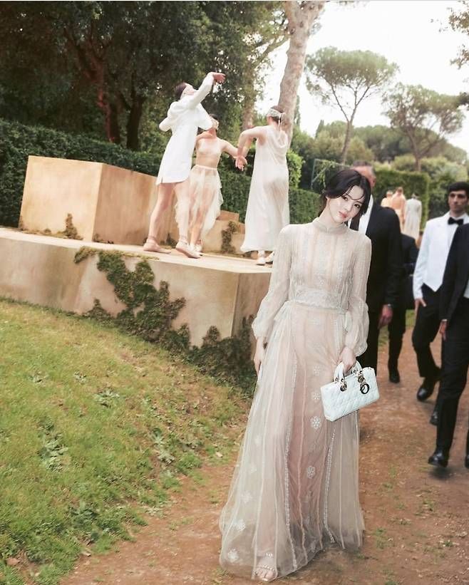 드레스는 몸을 감싸듯 흐르는 실루엣과 러플 디테일, 바닥까지 이어지는 길이감으로 그녀 특유의 우아하고 청초한 무드를 완벽히 살렸다.사진=한소희 SNS