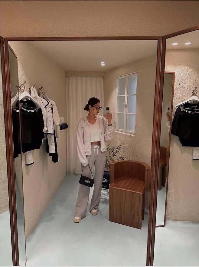 연그레이 크롭 후디에 조거 팬츠를 더한 ‘홈웨어 겸 외출룩’. 크롭 브라탑과 미니백으로 마무리하며 활동성과 세련미를 모두 챙긴 리얼 엄마 스타일링으로 완성됐다.사진=한지혜 SNS