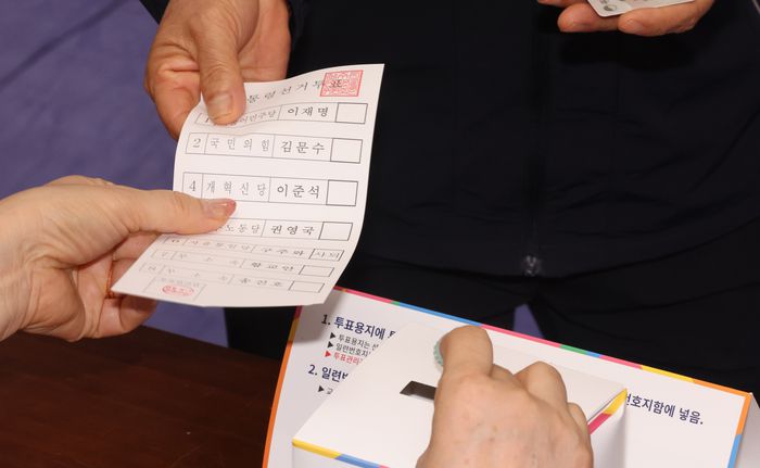 제21대 대통령 선거일인 3일 오전 제주도 제주시 제주도의회 의원회관 연동 제1투표소에서 한 유권자가 투표용지를 배부받고 있다. [사진 = 연합뉴스]