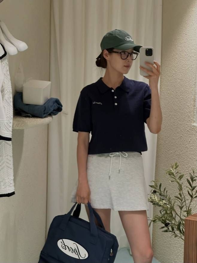 네이비 폴로셔츠에 밝은 그레이 쇼츠를 매치한 톤온톤 골프웨어 감성. 그린 컬러 캡과 네이비 토트백까지 더해지며 전체적으로 단정한 무드 속 액티브한 매력을 더했다.사진=한지혜 SNS