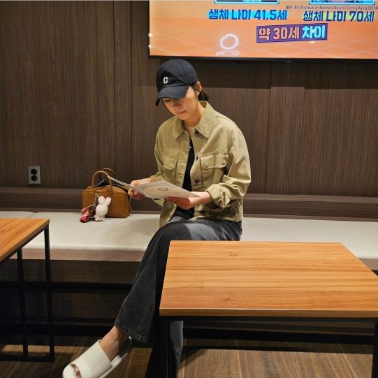 한가인은 베이지 야상과 블랙 볼캡, 슬리퍼로 편안한 데일리룩을 선보이며 한 헬스케어 공간에 앉아 있었다.사진=한가인 SNS