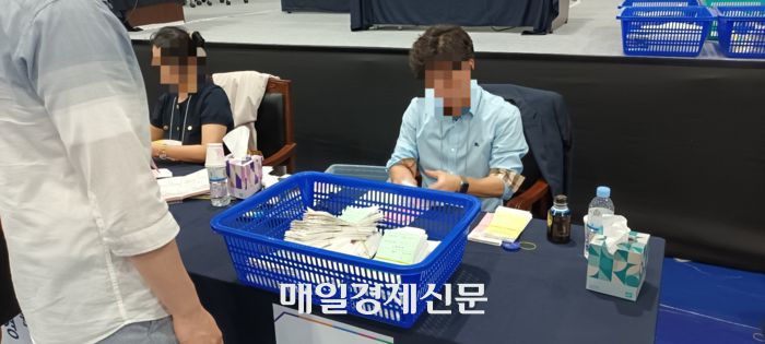 8명의 선거위원들이 차례로 개표된 투표용지에 이상이 없는지를 확인하고 있다. [사진 지혜진 기자]