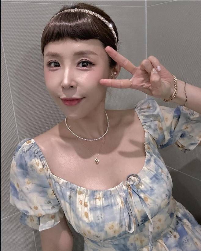 하늘빛과 옐로우 계열이 번진 듯한 원피스는 퍼프소매와 스퀘어넥 디자인으로 소녀미를 극대화했다.사진=신지 SNS