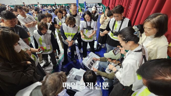 지난 4일 새벽 1시께 부정선거방지대에서 나온 개표참관인들이 본인들이 찍어놓은 사전투표함 봉인지 사진과 개표소에 도착한 투표함 봉인지 사진을 대조하며 이의를 제기하고 있다. [사진 지혜진 기자]