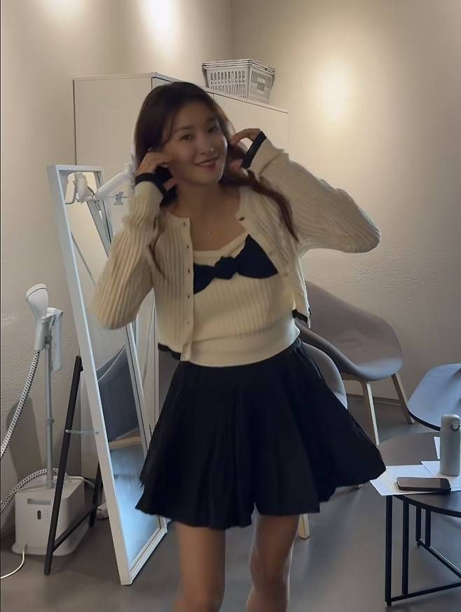클래식한 플리츠 디자인의 블랙 미니스커트를 매치해 사랑스럽고 발랄한 프레피룩을 완성했다.사진=이시영 SNS