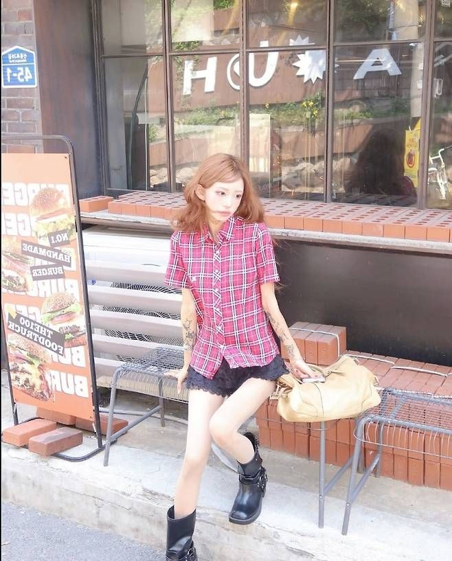 최준희는 레드 컬러의 클래식 체크 셔츠와 레이스 포인트가 더해진 블랙 미니 쇼츠를 매치해 단정하면서도 도발적인 스타일을 연출했다.사진=최준희 SNS