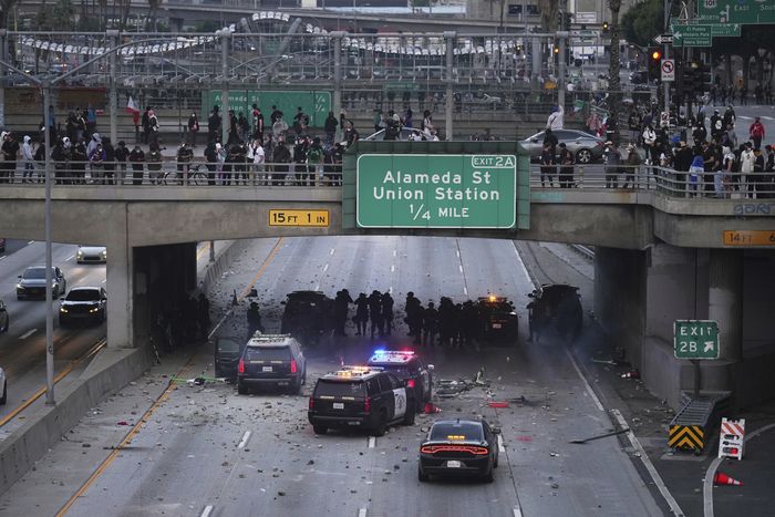 시위대가 전날 밤의 이민 단속 항의 시위에 이어, 2025년 6월 8일 일요일 로스앤젤레스 다운타운의 메트로폴리탄 구치소 근처 101번 고속도로 고가도로 아래에서 대피 중인 캘리포니아 고속도로 순찰대 차량에 물건을 던지고 있다. [사진 = AP 연합뉴스]