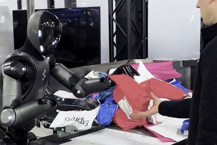 사람이 손을 내밀자 휴머노이드 로봇이 소포를 전달한다. [사진 = 피규어AI]