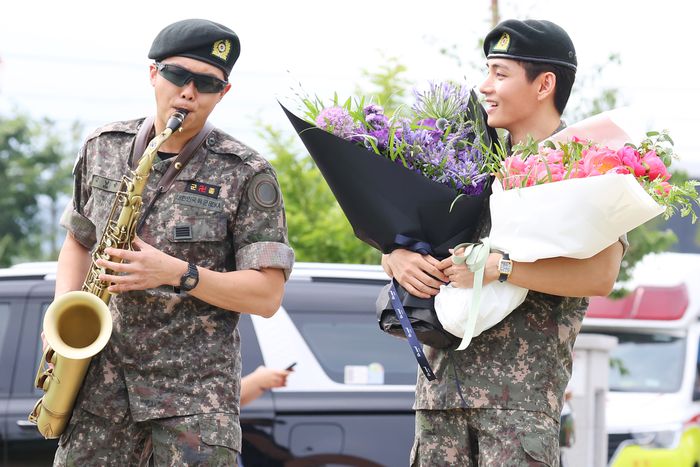 지난 10일  육군 현역 복무를 마치고 전역한 BTS RM(랩몬스터·왼쪽)이 전역식에서 색소폰 연주를 선보이고 있다. 오른쪽은 같은  날 전역한 뷔. [사진 출처=연합뉴스]