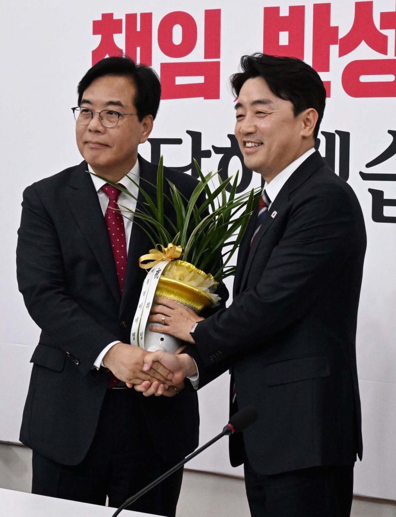 송언석 국민의힘 원내대표(왼쪽)가 17일 서울 여의도 국회 원내대표실에서 강훈식 대통령비서실장으로부터 축하 난을 받은 후 기념촬영을 하고 있다.