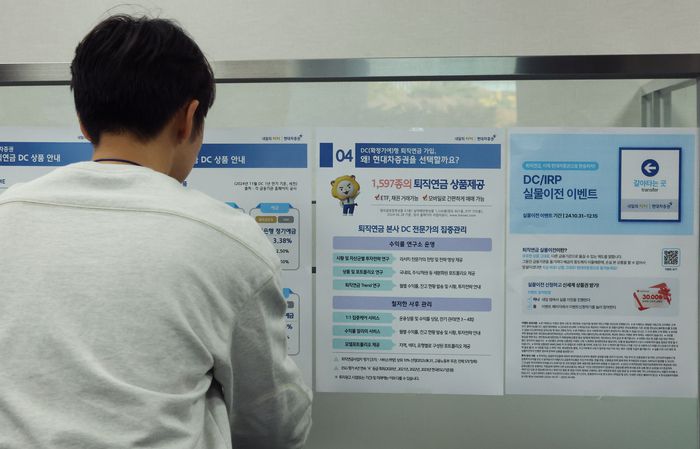 한 직장인이 퇴직연금 상품  소개 글을 읽고 있다. [사진 = 연합뉴스]