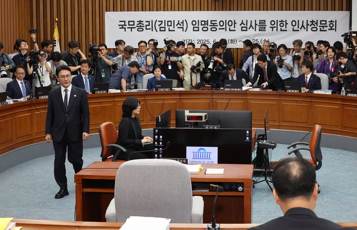 김민석 국무총리 후보자가 24일 서울 여의도 국회에서 열린 인사청문회에서 총리 후보자 인사청문특별위원회 위원장인 이종배 국민의힘 의원에게 선서문을 제출한 뒤 자리로 돌아가고 있다. [사진 출처 = 연합뉴스]