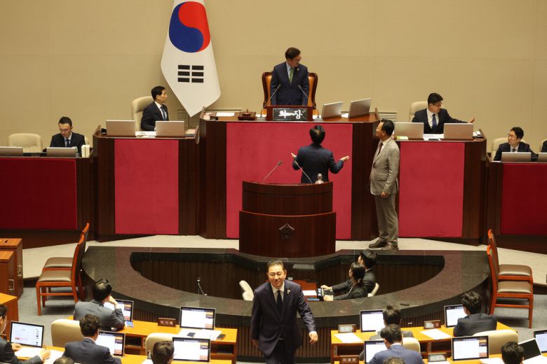 우원식 국회의장이 27일 여의도 국회에서 상임위원장 선출을 위한 본회의를 열자 국민의힘 송언석 원내대표와 유상범 원내수석부대표가 단상으로 올라가 항의하고 있다. 김병기 더불어민주당 대표 직무대행 겸 원내대표는 얼굴에 미소를 띤 채 자리로 돌아가고 있다.  한주형 기자